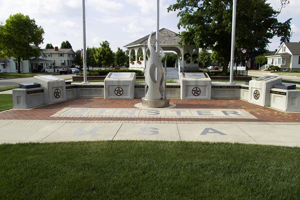 Memorial marker with the words "Minster, USA" on the ground in front